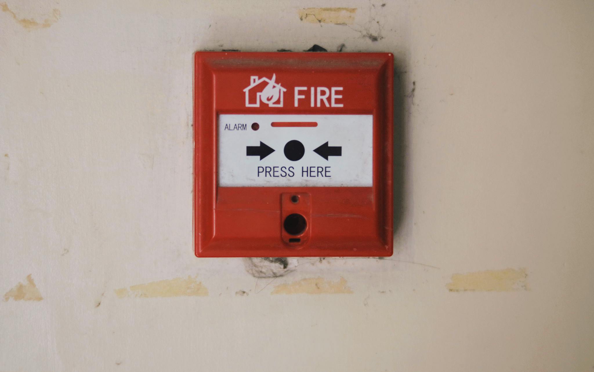 Emergency safety fire detection system box for safety with inscription and push button placed on white wall in light room